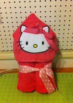 a hello kitty towel is sitting on top of a cutting board with a pink polka dot bow