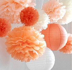 tissue pom poms hanging from the ceiling in an orange and white color scheme