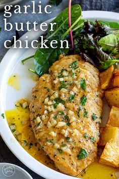 a white plate topped with chicken, potatoes and greens next to a side of salad