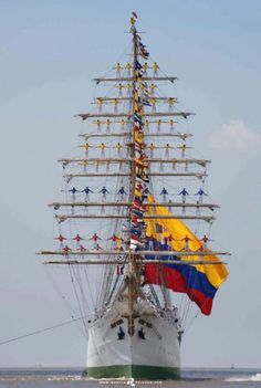 a large boat with many people on it's sails is in the middle of the water