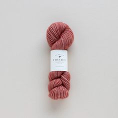 a skein of pink yarn sitting on top of a white surface