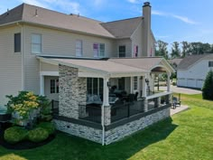 an aerial view of a large house with a covered porch and patio area in the front yard