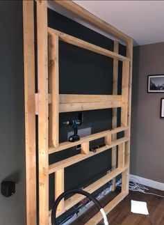 there is a large wooden book shelf in the living room with pictures on the wall