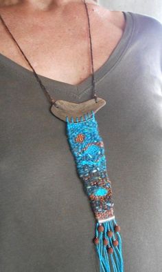 a woman wearing a gray shirt and blue beaded necklace with a bird on it