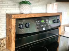 a black stove top oven sitting inside of a kitchen next to a white brick wall