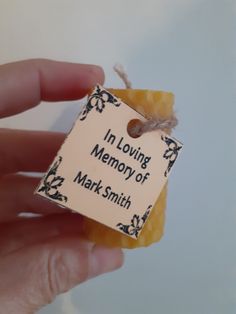 a hand holding a piece of wax paper with the words in loving memory of mark smith on it