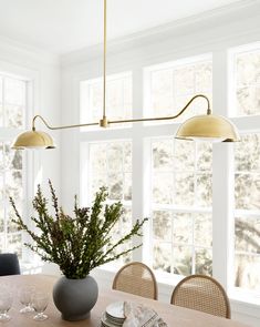 a dining room table with chairs and a vase filled with flowers on top of it