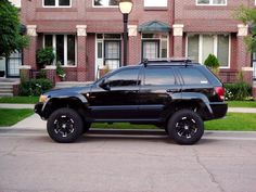 a black suv parked in front of a brick building