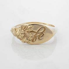 This vintage-inspired floral ring is a row of dainty flowers wrapped around your fingers. Handmade and polished, it is available in solid 8K and 14K gold. This item is engravable with text or monogram of your choice at no extra cost. The initals are engraved onto the ring and embedded in the 3D model for a flawless embossed finish. It is also possible to add a diamond or birthstone or diamond to this ring at an additional fee. Please inquire for details. A few notes about our gold:- Though we do Heirloom Birth Flower Jewelry, Dainty Oval Yellow Gold Flower Ring, Vintage Initial Ring For Anniversary, Tarnish Resistant, Vintage 14k Gold Flower Promise Ring, Elegant Signet Ring With Birth Flower For Anniversary, Gold Engraved Delicate Rings, Vintage Wedding Signet Ring Tarnish Resistant, Delicate Engraved Gold Rings, Elegant Anniversary Signet Ring With Birth Flower