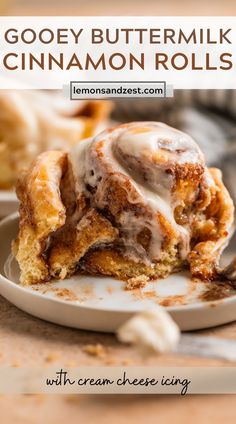 gooey buttermilk cinnamon rolls with cream cheese icing on a white plate