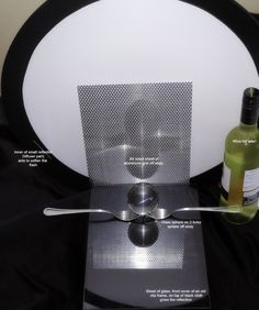 a bottle of wine sitting on top of a table next to a plate with spoons