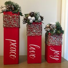 three red vases decorated with christmas decorations