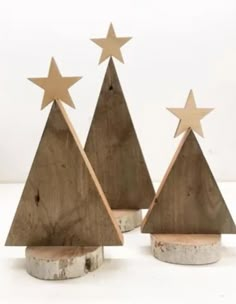 three wooden christmas trees with stars on them