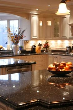 a bowl of fruit sitting on top of a kitchen counter