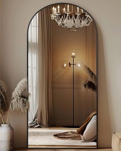 an arch shaped mirror in the corner of a room with a chandelier hanging from it