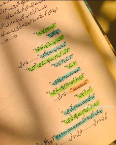 an open book with arabic writing on the pages and green marker marks in different languages