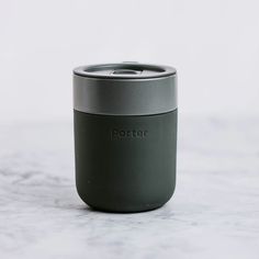 a coffee cup sitting on top of a marble counter next to a white wall with the word porter written on it