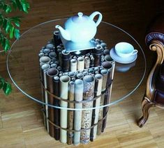 a glass table topped with lots of candles and a tea pot sitting on top of it