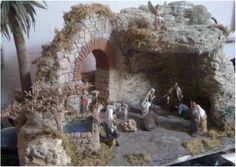 there are many figurines on display in front of a stone wall and palm trees