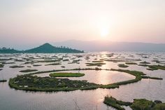 the sun is setting over an island with many small islands in the middle of it