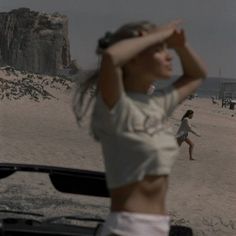 a woman standing on top of a sandy beach