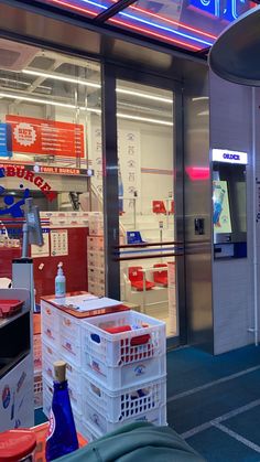 the inside of a store with many items in front of it and neon signs above them