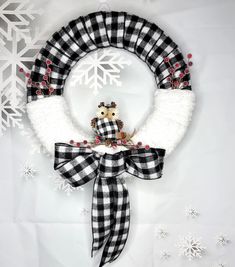 a black and white wreath with a teddy bear on it