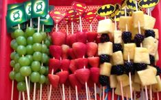 some fruit is arranged on skewers in the shape of batmans and grapes