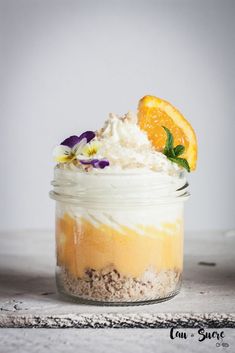 an orange and white dessert in a glass jar