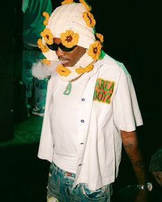 a man in a white shirt and flowered hat