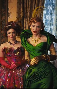 two women dressed in green and red sitting next to each other