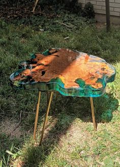 an old table is sitting in the grass with some paint on it's surface