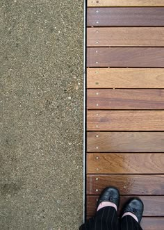 a person standing on top of a wooden floor next to a wall with wood slats