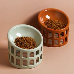 two bowls filled with food sitting on top of a pink table next to each other