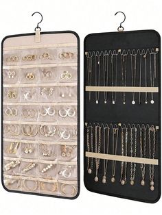 two black trays with earrings and necklaces in them, one is hanging from the wall