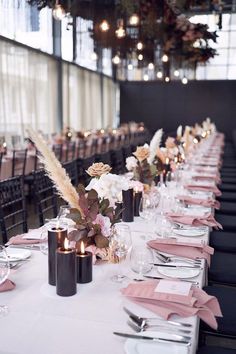 a long table is set with pink napkins and silverware for an elegant dinner