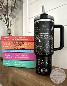 a stack of books sitting on top of a wooden shelf next to a coffee mug