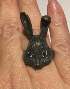 a person's hand with a ring in the shape of a rabbit