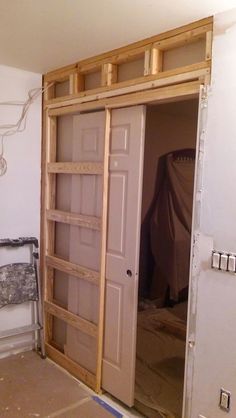 an unfinished room with wooden shelves and doors