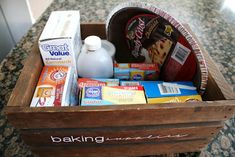 a wooden box filled with food on top of a counter next to a bottle of milk