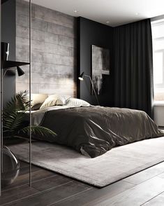 a bedroom with black walls and wooden flooring has a large bed in the middle