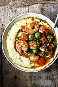 a bowl filled with shrimp and vegetables on top of mashed potatoes