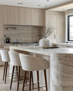 a kitchen with marble counter tops and bar stools