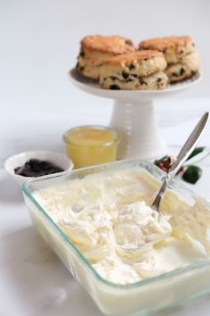 a bowl of ice cream with cookies and jam in the background on a white table