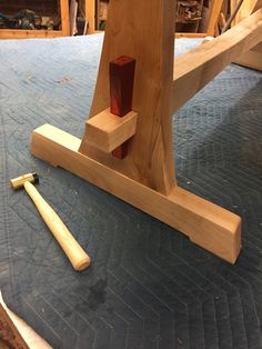 a piece of wood sitting on top of a bed next to a pair of hammers