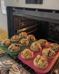 muffins sitting on trays in front of an oven