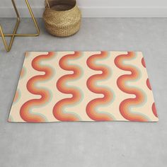 a rug with an abstract design on it next to a basket and chair in a room