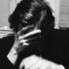 black and white photograph of a man covering his face