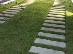 a stone path in the grass between two buildings