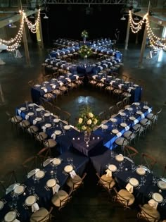 an overhead view of a banquet hall with blue tablecloths and white place settings